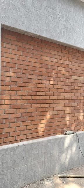 Exterior brick panel set in grey textured tiles