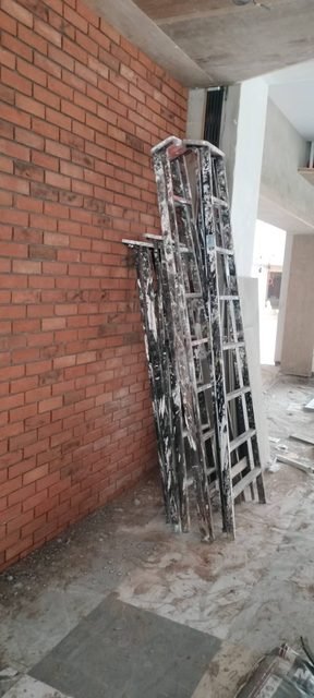 Brick wall during fitting, with ladders on site